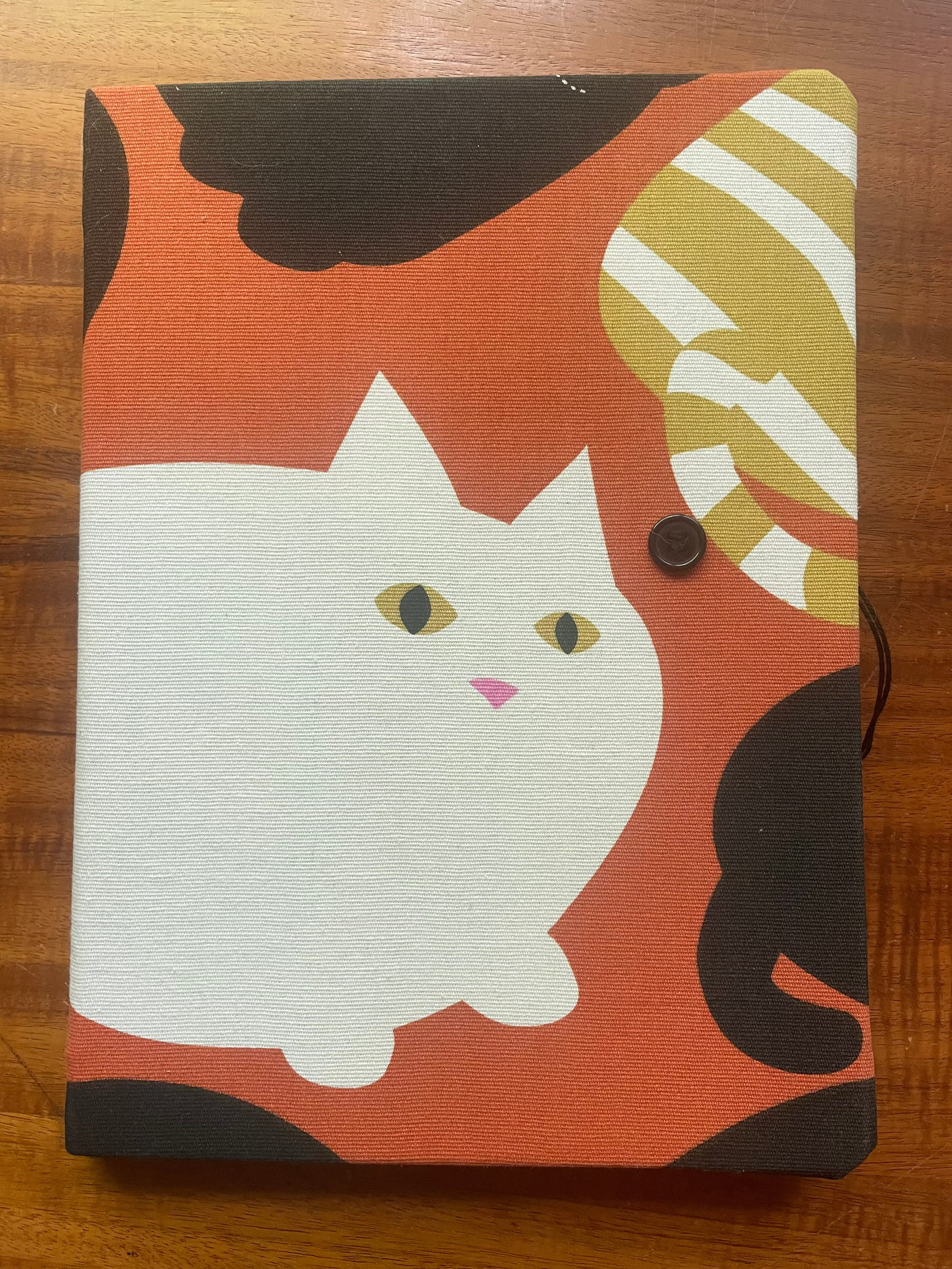 Notebook with a cat illustration on a wooden surface